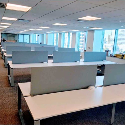A vacant office space featuring several desks and chairs, highlighting a clean and organized environment.