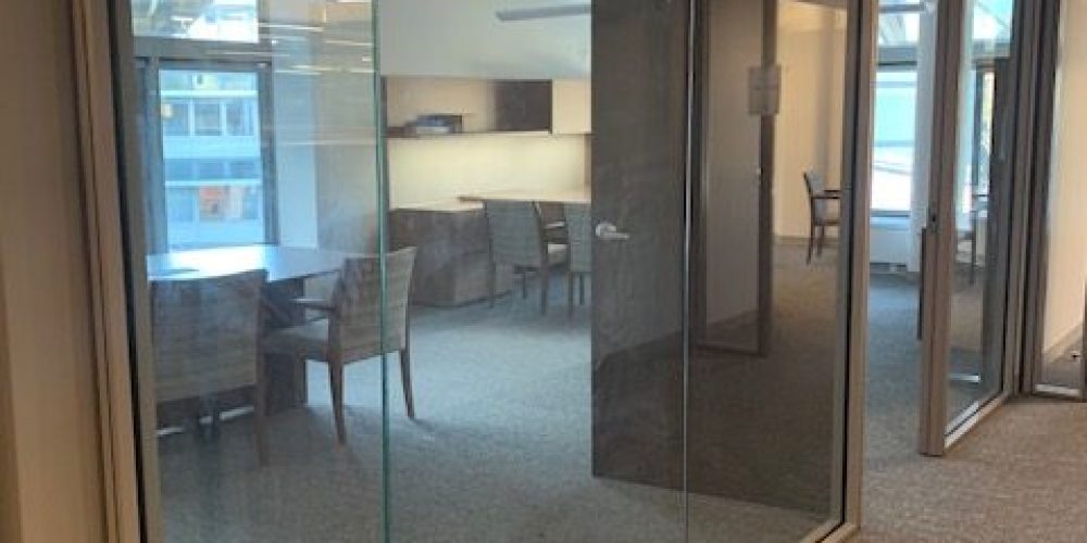 A glass room office with office chairs and tables.