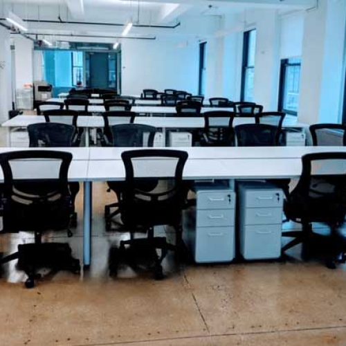 A vacant office space featuring several desks and chairs, highlighting a clean and organized environment.