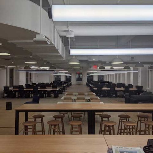 A spacious room featuring multiple tables and chairs arranged for gatherings or meetings.